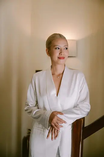 Cô dâu đứng trên cầu thang, ánh sáng ấm áp tạo nên chân dung nhẹ nhàng trong khoảnh khắc get ready trước lễ cưới.