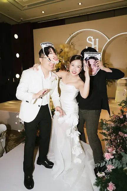 Wedding guests and bride posing with custom photo masks at modern ballroom wedding