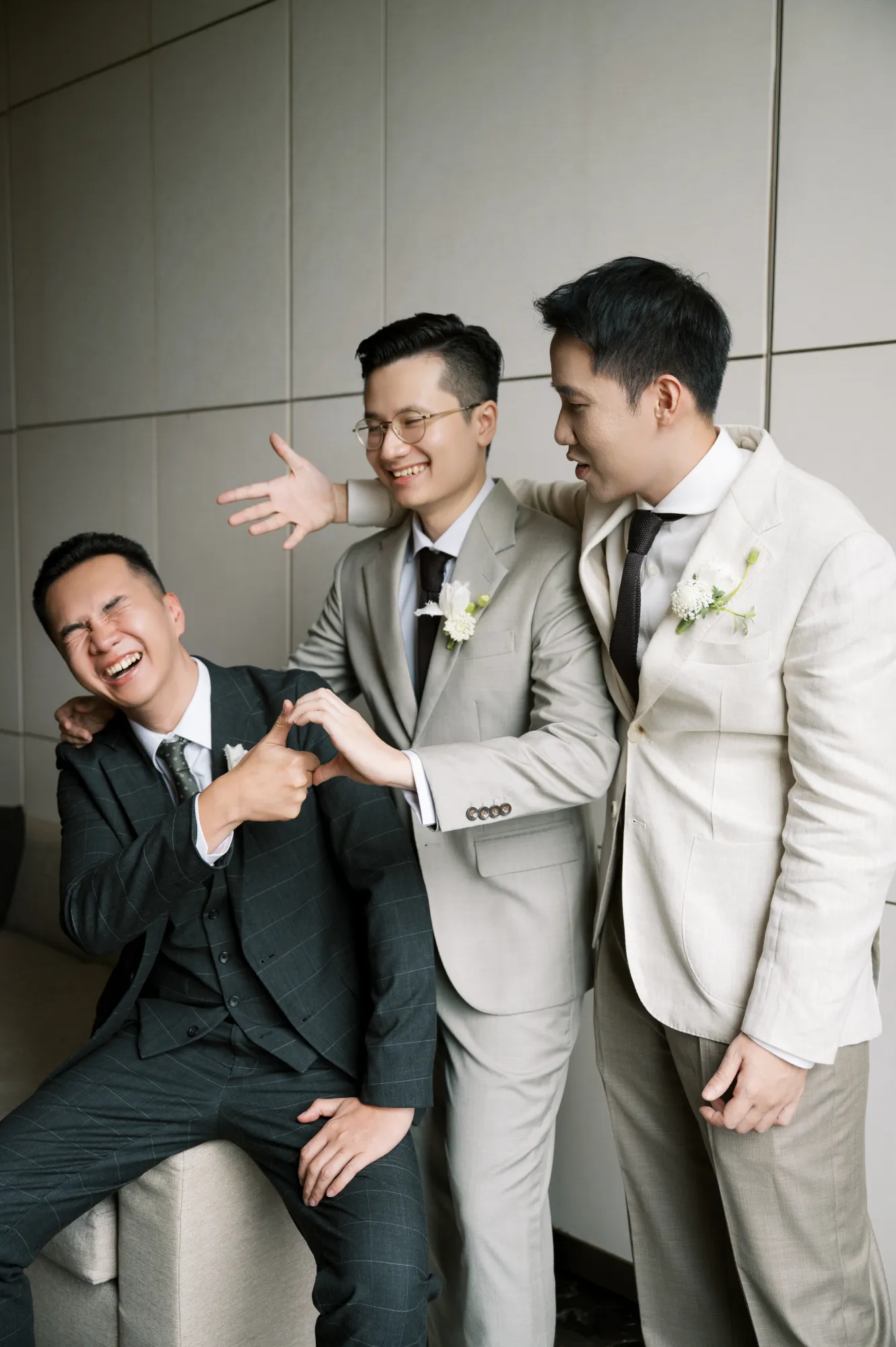 Chú rể và các phù rể cười vui vẻ trong khoảnh khắc chuẩn bị trước lễ cưới, thể hiện tình bạn và niềm hạnh phúc.