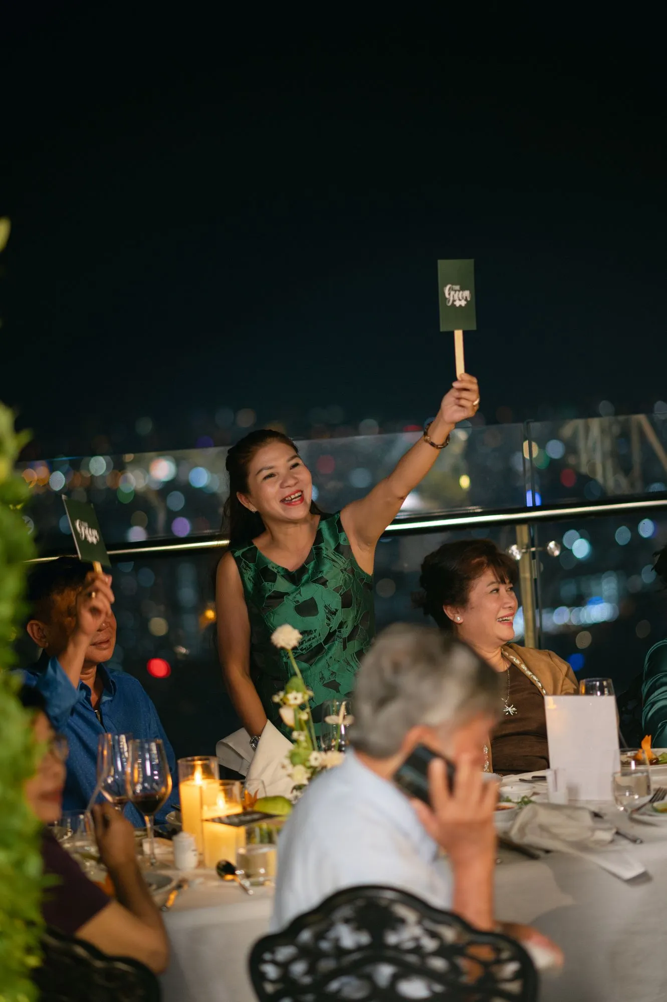 Khách mời giơ bảng cổ vũ đầy hào hứng khi tham gia game trong bữa tiệc tối.