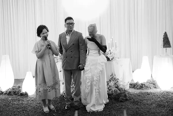 A speech moment given by mom during the wedding reception as the couple listens on stage.
