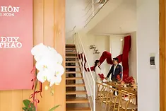 Không gian bàn tiệc trong nhà với sắc đỏ ấm áp và hoa trang trí