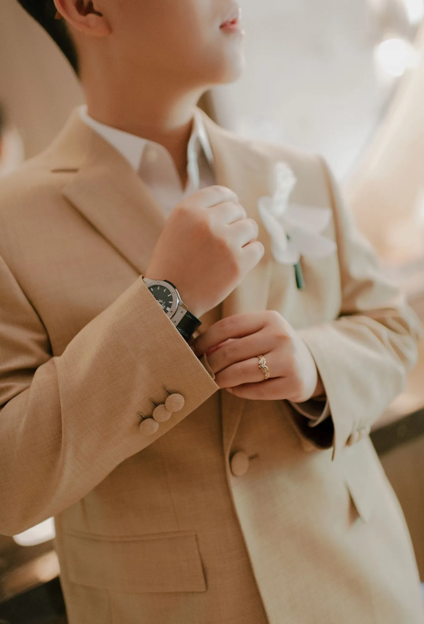 Close-up of the groom adjusting his watch and cuff, emphasizing attention to style and grooming tips from a wedding groom guide.