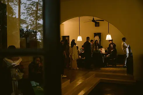 Friends gathered around a table during an intimate evening moment before the wedding.