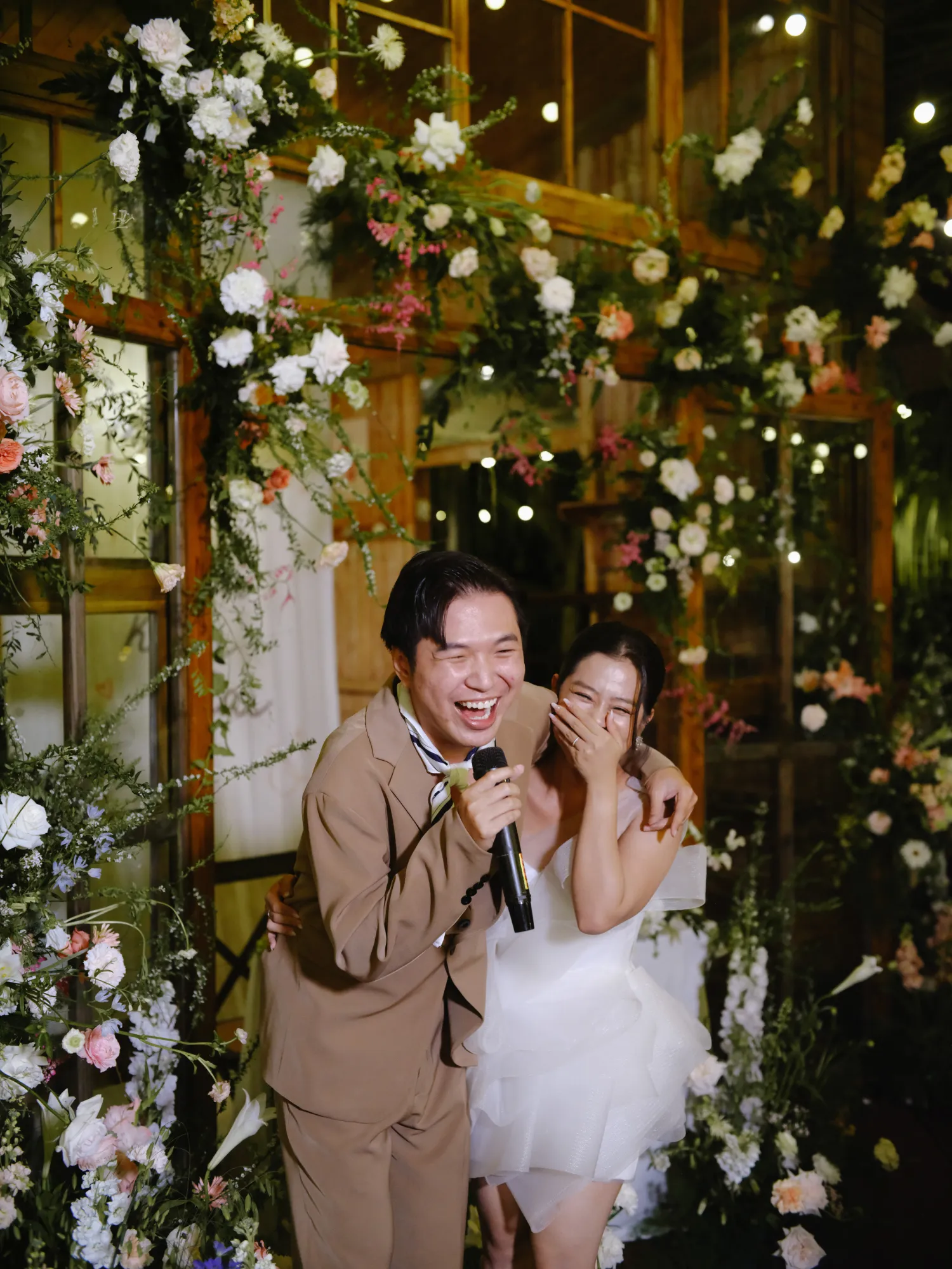 Bride and her friend share a warm laugh at their reception party.