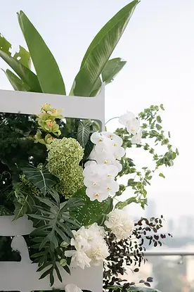 Cận cảnh backdrop hoa xanh trắng với lá nhiệt đới trong lễ cưới rooftop
