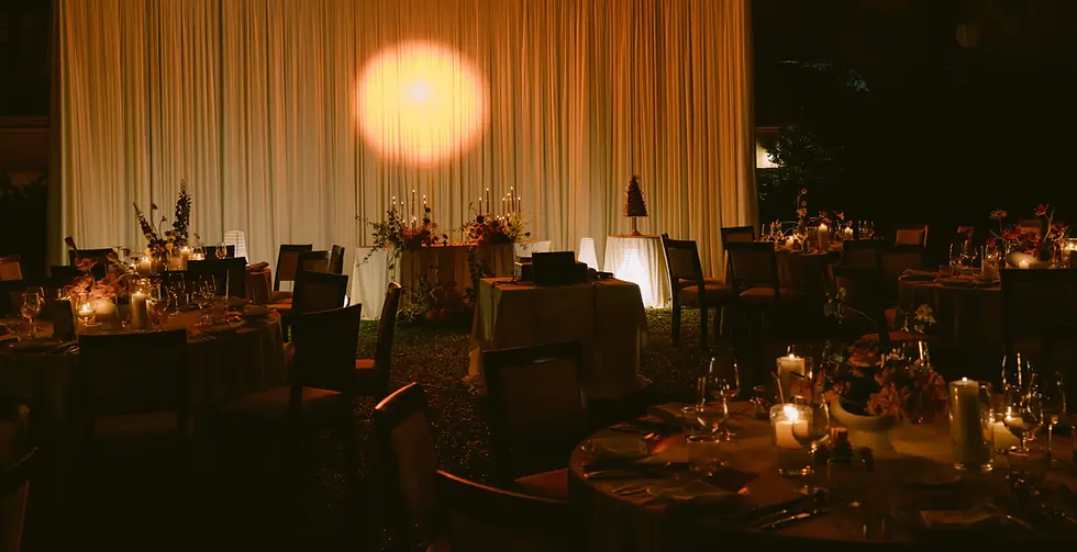 Không gian tiệc cưới buổi tối với ánh nến ấm áp và bàn tiệc được bày trí tinh tế.