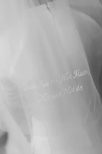 Close-up of delicate embroidery on a bridal veil with a romantic handwritten message.