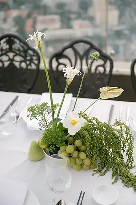 Hoa trang trí trung tâm bàn tiệc cưới với sắc xanh tự nhiên và trái cây điểm xuyết