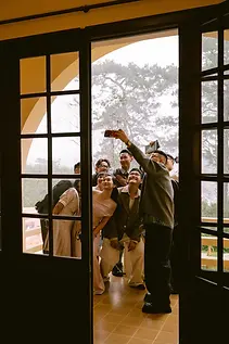 Group of friends leaning together to take a selfie on a balcony.