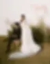 Couple wedding portrait, bride in strapless dress and groom seated beside, styled with natural grass décor.