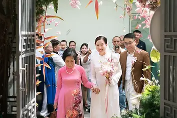 Bride walking into the groom's house with mom & relatives during a Vietnamese tea ceremony.