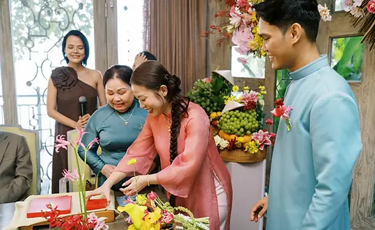 Bride presenting engagement gifts during a traditional ceremony inside a garden venue