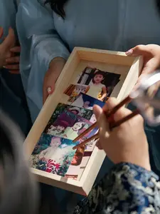 A wedding gate game where family members use childhood photos as a playful challenge during the groom’s arrival.
