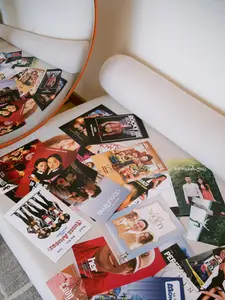 Wedding seating chart displayed as movie-themed postcards on a cushioned bench with a mirror.