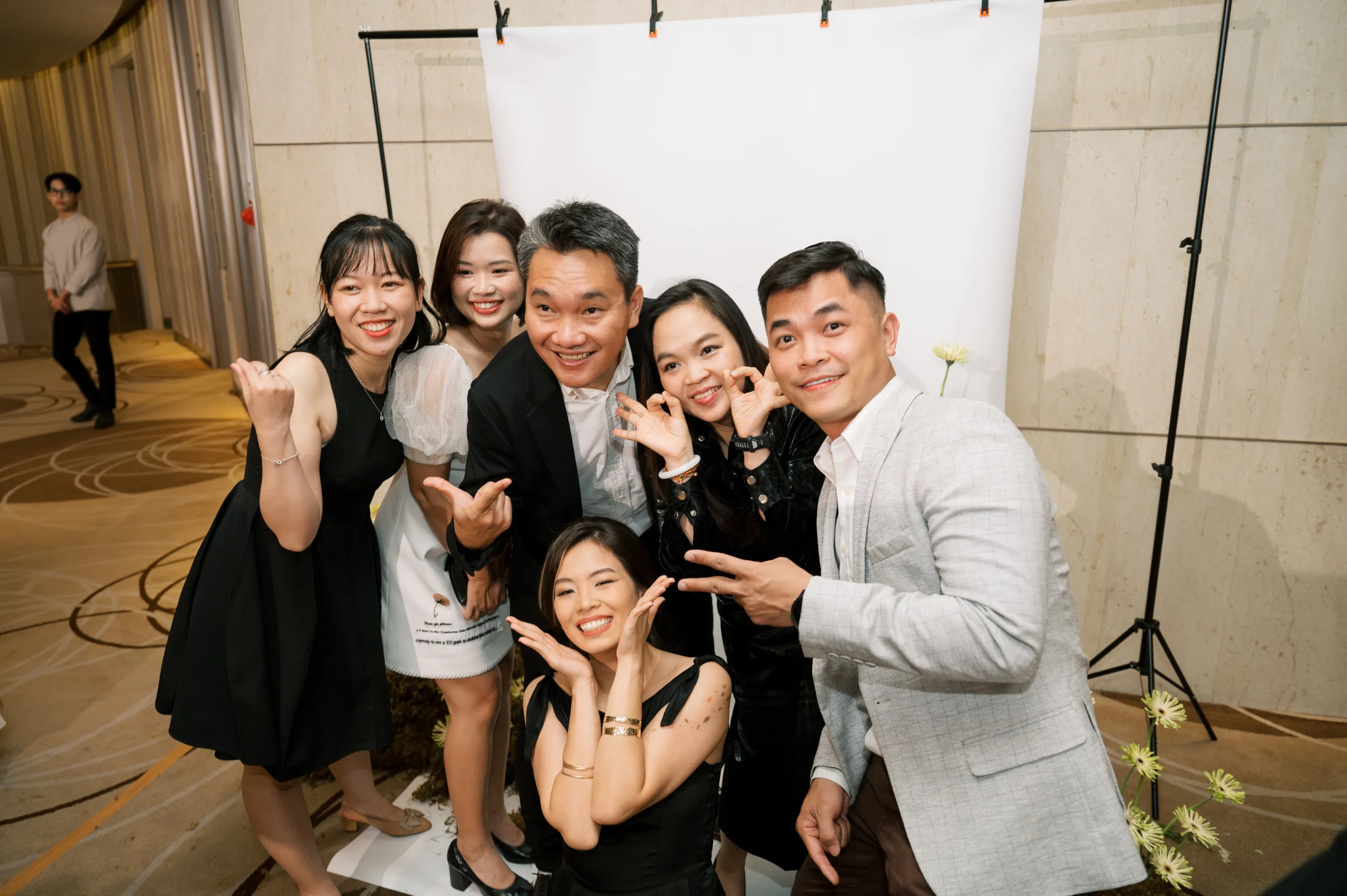 Friends and family members pose cheerfully, capturing memorable and joyful wedding moments.