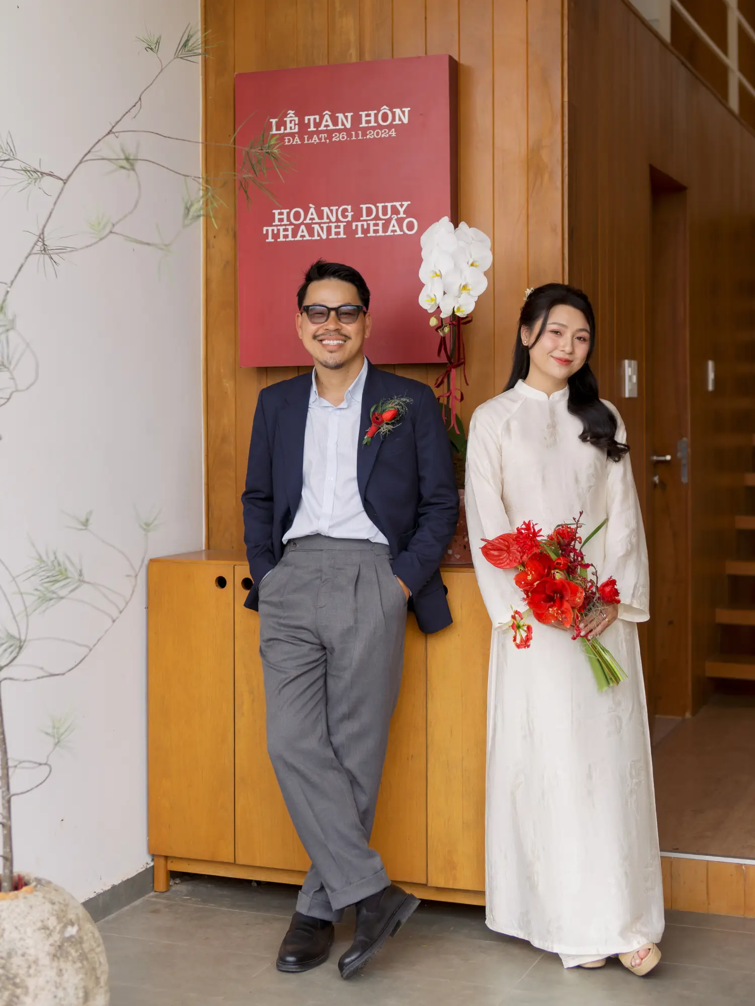 Cặp đôi trong trang phục áo dài truyền thống, mỉm cười rạng rỡ trước lễ tân hôn, tạo nên khoảnh khắc ấm áp và gần gũi.