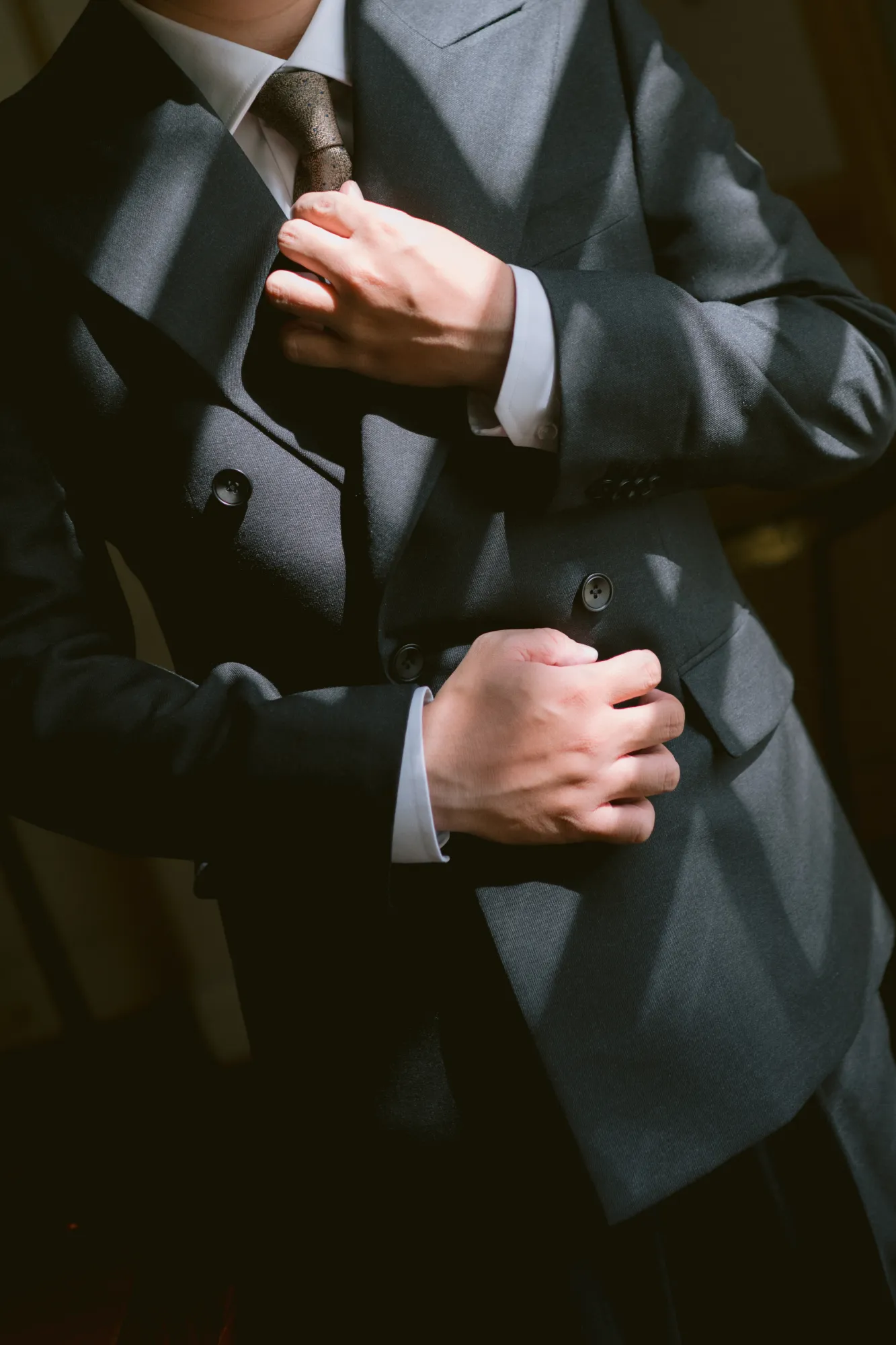 Close-up of a groom fixing his suit.