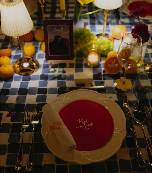 An intimate evening wedding table setup with candles, glassware, flowers, and personalized table details