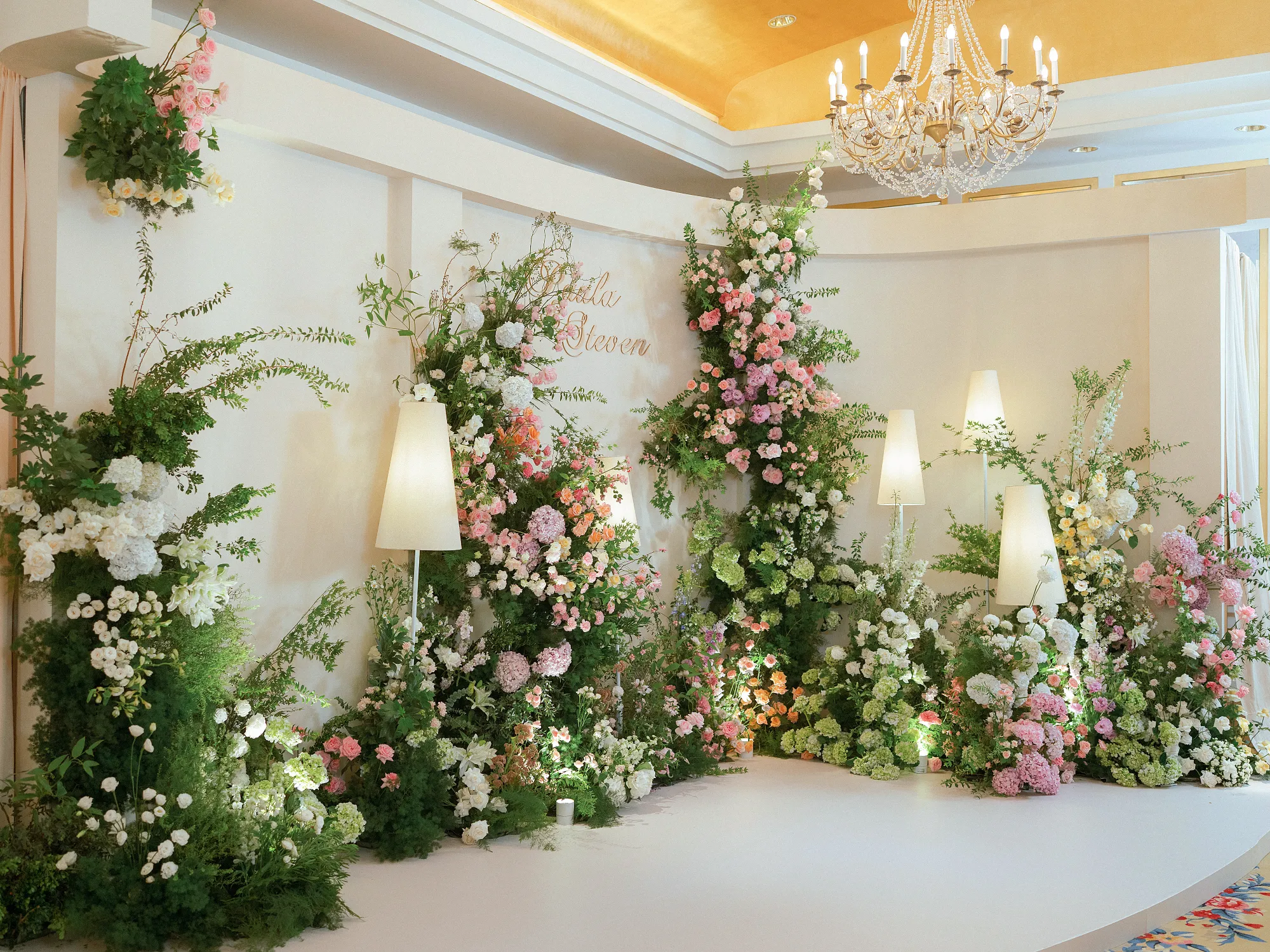 Khu chụp ảnh lễ cưới của Paula & Steven với thiết kế ngập tràn hoa lá, ánh sáng ấm áp và không khí gần gũi, thân mật.