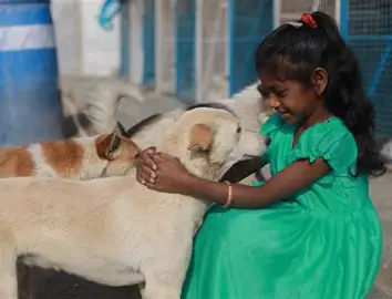 A young girl embraces an indie dog