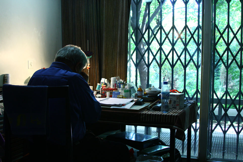 Ezzatollah Entezami at his desk in "... and the blue sky" by Ghazaleh Soltani