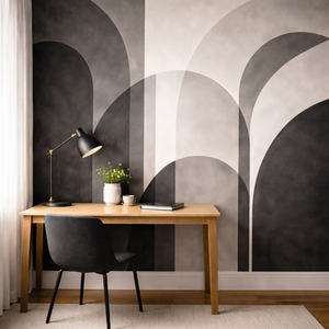 Contemporary home office with a painted accent wall showcasing bold arch designs in black, grey, and soft neutral shades behind a wooden desk.