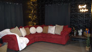Romantic lounge area with large red sectional sofa, warm string lights, and moody decor in adults-only themed vacation rental