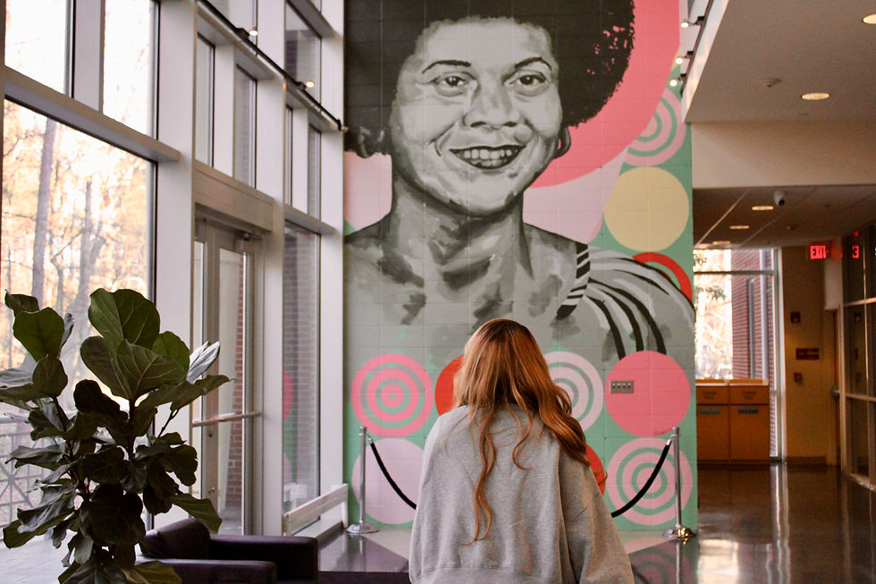 Isabella in front of a mural she looks at whenever in the Stone Center.