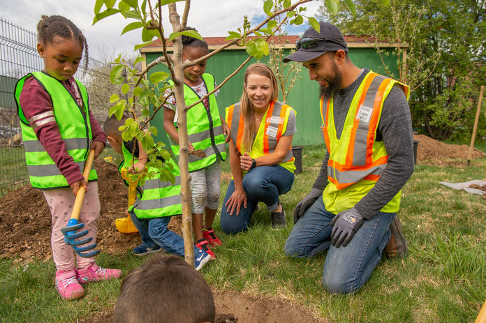 Volunteers planting a tree with children