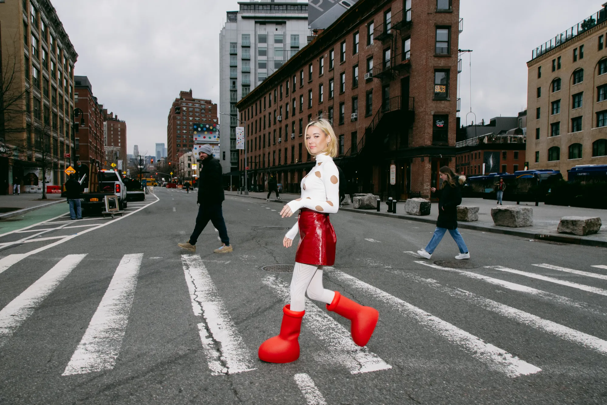 MSCHF Big Red Boots campaign featuring oversized cartoon-style red boots worn in surreal streetwear editorial setting