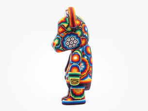 Colorful bear figurine with intricate bead patterns stands in profile against a white background, displaying vibrant geometric designs.