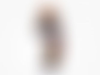 Colorful bear figurine with intricate bead patterns stands in profile against a white background, displaying vibrant geometric designs.