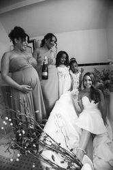 Bride seated with members of the wedding party and young guests during preparations, in black and white at Monkey Island Estate.