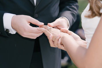 Close-up of the groom placing a ring on the bride’s finger at Monkey Island Estate.