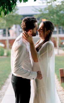 Bride resting her hand on the groom’s neck as they smile at each other in the Silchester Farm garden.