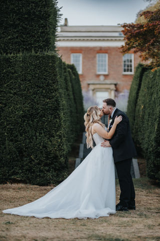 Bride and groom sharing an intimate moment on the castle grounds at Hedingham Castle