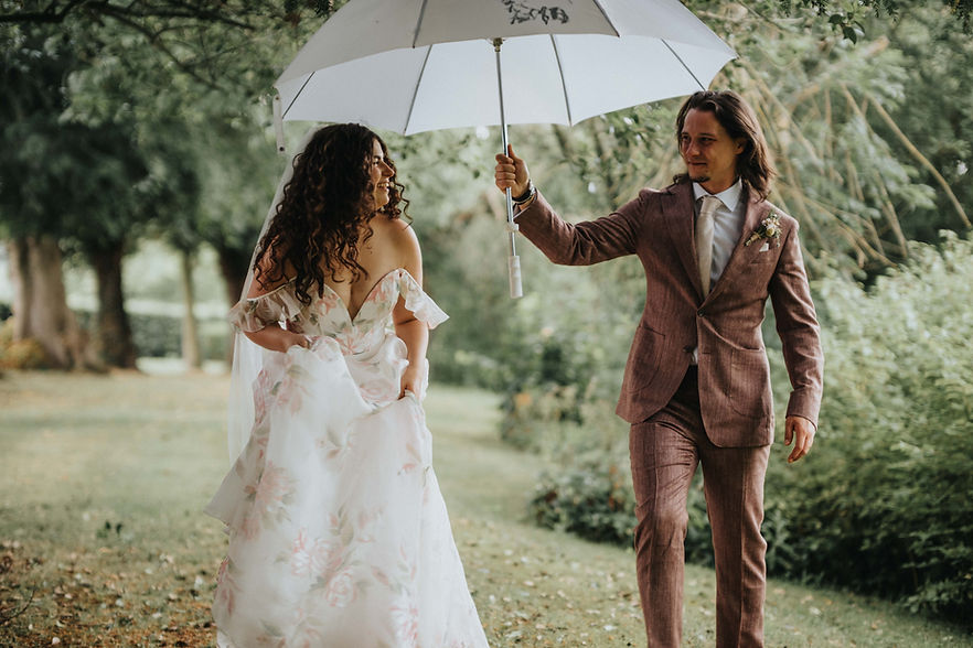 bride and groom walking in the rain