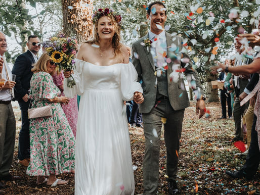 Bride and groom walking through biodegradable paper confetti