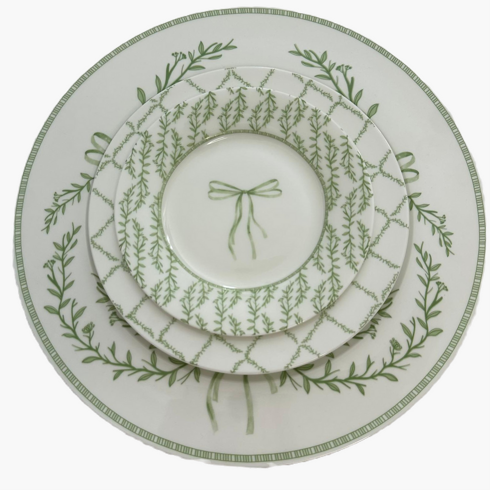 White bow dinner plate with green botanical wreath design for elegant tableware rental