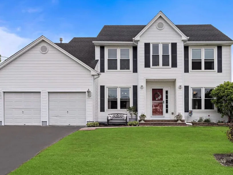 Two-story white house with a two-car garage, one of our sold properties.
