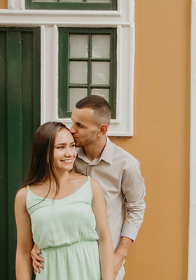 Casal em frente a casa colorida