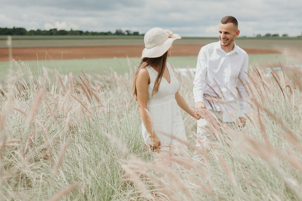 Casal caminhando em campo de capim