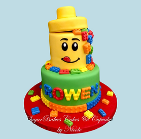 Lego themed Birthday cake with edible lego pieces and a lego edible lego toy box on the top.