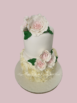 Pink Floral Wedding cake with buttercream rosettes on the bottom tier and pink roses throughout.