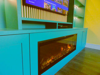 Custom wall to wall media / tv unit with fire and wood slat feature back in teal
