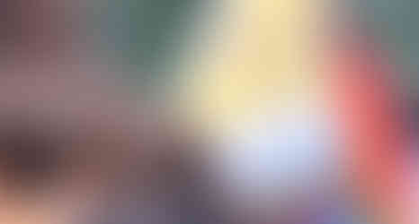 Students standing with the Pride Flag at a rally