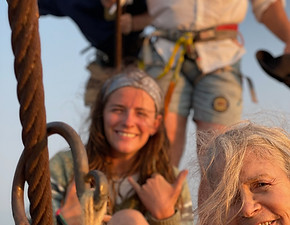 four people smiling at the bow with ropes in their hands