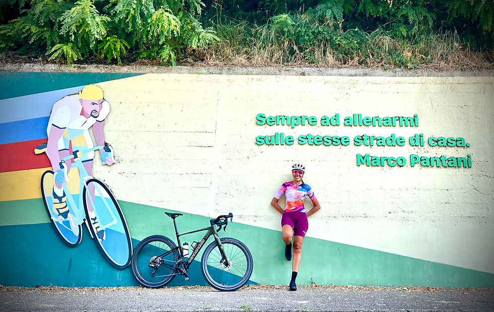 Mulher encostada em uma parede com a bicicleta, em rota de bike na Itália