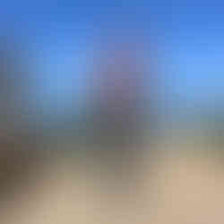 Mulher de bicicleta em frente ao mar